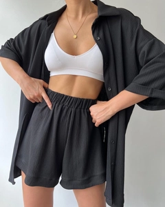 Detail of three-piece set with black shirt, white tank top, and textured shorts