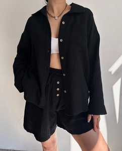 Detail of black textured cotton shirt and drawstring shorts with button accents