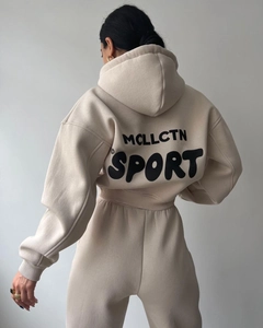 Détail survêtement beige en polaire avec impression MCLLCTN SPORT au dos et capuche