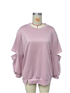 Détail d'un sweat-shirt rose avec découpes aux coudes et fentes latérales au bas