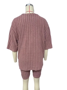 Back view of women's ribbed knit two-piece set featuring loose top and tight shorts in mauve