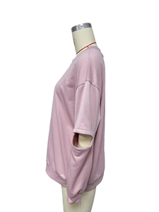 Vue détaillée du sweat-shirt rose avec découpes tendance aux coudes et poignets côtelés