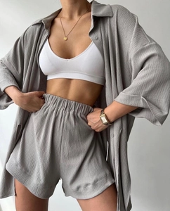 Detail of grey pleated fabric texture on three-piece set with shirt and shorts