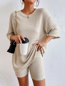 Close-up of beige ribbed knit texture on loose top and cycling shorts two-piece set