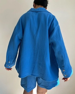 Detail of blue crinkled fabric texture on long sleeve shirt and high waist shorts