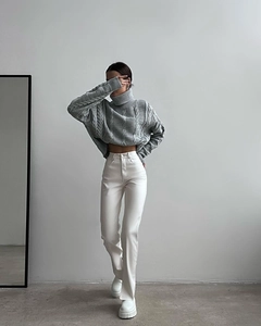 Detail of grey cable-knit turtleneck sweater with drop shoulders and ribbed texture