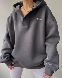 Détail d'un sweat à capuche gris foncé avec col en V et logo de marque imprimé blanc