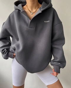 Détail du sweat à capuche gris foncé avec col en V et lettrage blanc MAI STUDIOS CO