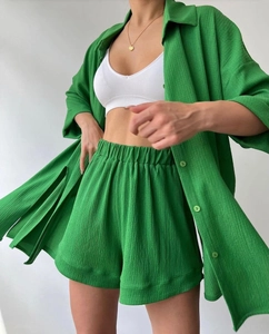Detail of green linen-textured two-piece set featuring split sleeves and drawstring shorts