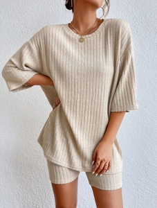 Detailed close-up of beige ribbed knit texture on a loose T-shirt and shorts set