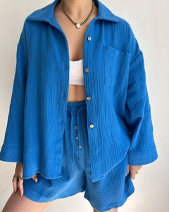 Detail of blue crinkled fabric texture on long sleeve shirt and drawstring shorts