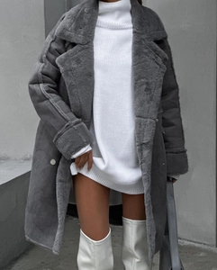 Detail of grey faux fur coat with lapels and white chunky knit sweater dress for winter