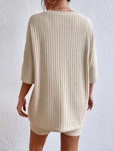 Rear view of beige ribbed knit lounge set featuring round neck top and loose shorts