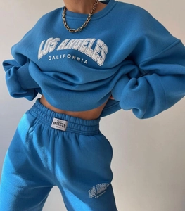 Detail of blue Los Angeles print tracksuit with branded woven label on the joggers