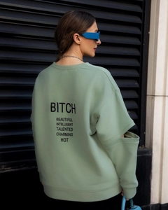 Détail d'un sweat-shirt vert clair avec manches ajourées et imprimé au dos
