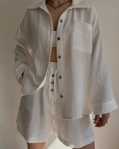Detail of white gauze two-piece set showing premium textured fabric and wooden buttons