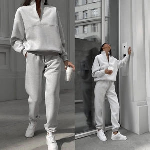 Detail of light gray two-piece tracksuit featuring half-zip collar and jogger cuffs
