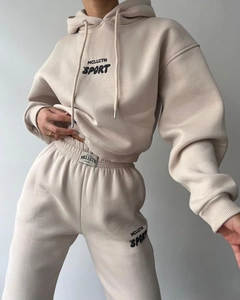 Détail du survêtement en polaire beige avec imprimé MCLLCTN SPORT et étiquette à la taille