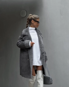 Detail view of winter suede fur coat with lapel collar and white over-the-knee leather boots