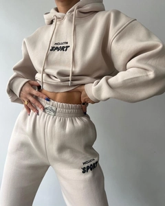 Détail du survêtement beige en polaire avec imprimé MCLLCTN SPORT et étiquette tissée
