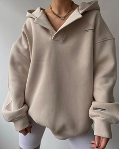Gros plan détaillé d'un sweat à capuche beige oversize avec logo MAI STUDIOS CO et col polo