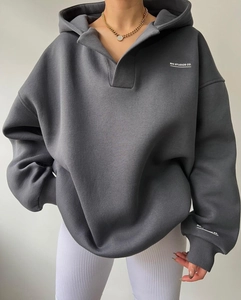 Détail du sweat à capuche en molleton gris foncé avec col à revers et imprimé blanc