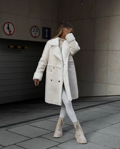 Detail of beige faux suede winter coat with thick white shearling lining and double-breasted design