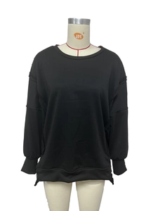Detailweergave van zwarte oversized sweatshirt met zichtbare stiksels en zijsplitje