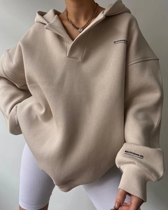 Détail de l'imprimé logo Mai Studios sur un sweat à capuche beige surdimensionné