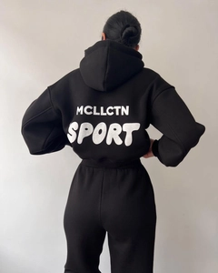 Vue arrière du survêtement noir avec inscription blanche MCLLCTN SPORT sur le sweat à capuche