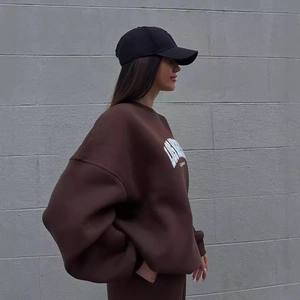Women's streetwear set featuring a brown oversized printed sweatshirt and a black baseball cap