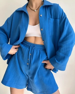 Detail of blue crinkle fabric two-piece set featuring shirt buttons and drawstring waist