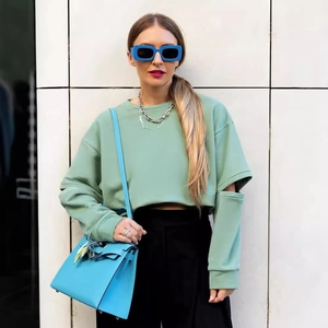 Sweatshirt femme vert clair avec manches découpées et pantalon noir taille haute chic