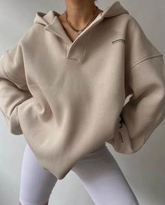 Détail d'un sweat à capuche en coton épais beige avec impression du logo noir