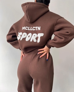 Détail du dos du survêtement marron foncé montrant l'imprimé blanc MCLLCTN SPORT