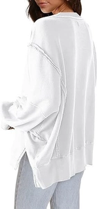 Detail van oversized wit sweatshirt met zichtbare naden en een zijsplit aan de zoom