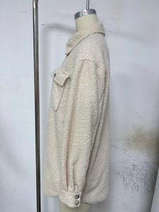 Detail view of beige fleece shirt jacket with flap pockets and plush wool-like texture