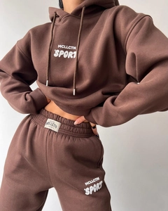 Détail d'un ensemble de survêtement marron foncé avec sweat à capuche et logo de sport
