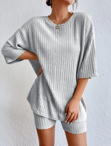 Detail of light grey ribbed knit texture on stylish two-piece loose top and shorts set