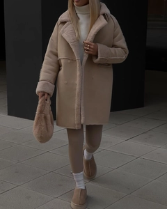 Detail of winter suede coat featuring thick plush lining and premium beige faux fur texture