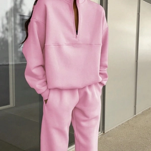 Pink fleece two-piece sweatsuit featuring a half-zip pullover and matching joggers