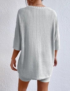 Detail of light grey ribbed knit loungewear set featuring loose top and slim shorts