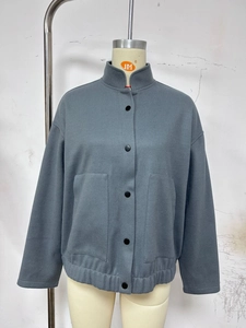 Close-up of gray stand-collar jacket featuring button closure and elasticized hem detail