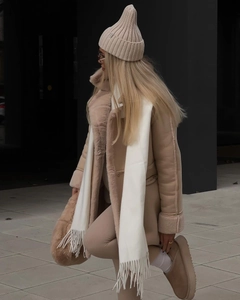 Close-up of winter faux fur suede coat with scarf, knit leggings and snow boots