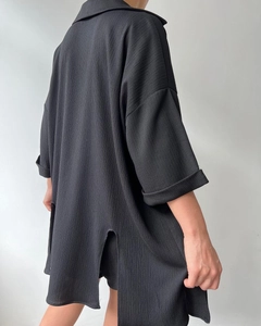 Detail of black textured fabric on longline split-side shirt with drop shoulders