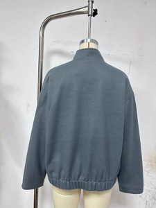 Detail view showing the grey-blue fleece jacket back, stand collar and elastic hem feature