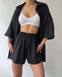 Detailed close-up of black ribbed texture fabric on minimalist shirt and shorts set