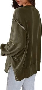 Detailweergave van de oversized donkergroene trui met zijsplitjes en zichtbare naden
