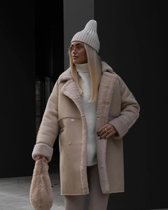 Detail of beige faux shearling coat showing thick plush trim on lapel and cuffs