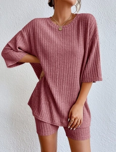 Detail of dry rose pink ribbed fabric on a loose T-shirt and slim biker shorts set